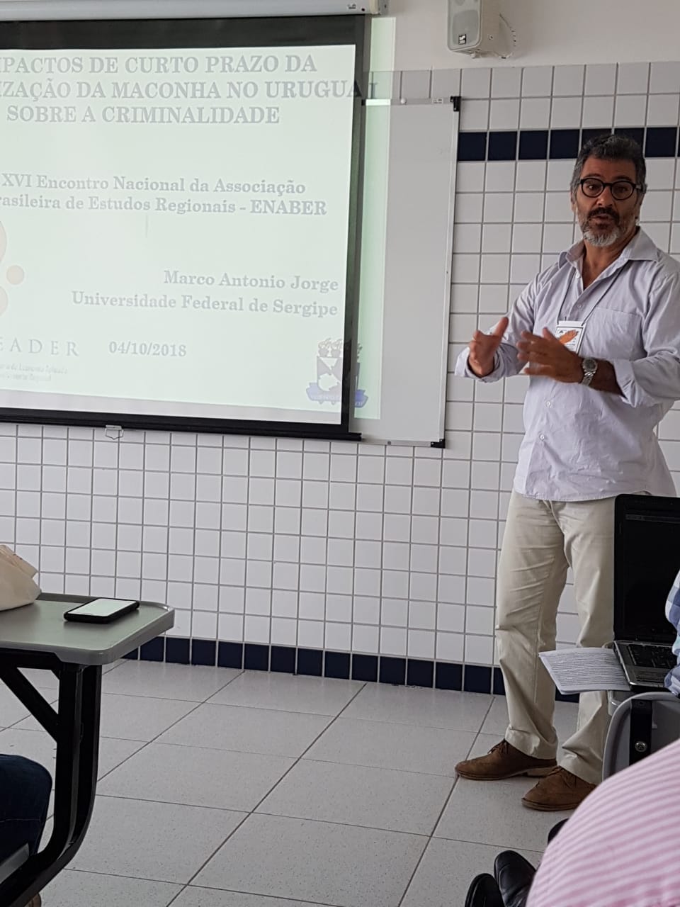 O professor Marco Jorge apresentando a sua pesquisa "Impactos de Curto Prazo da Legalização da Maconha no Uruguai sobre a Criminalidade: Uma análise utilizando controle sintético"